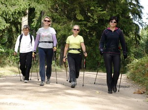 Cztery osoby uprawiające Nordic Walking