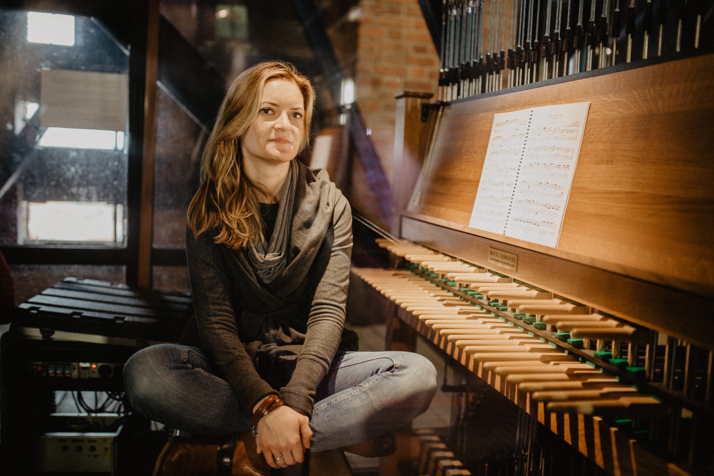 Miejska carillonistka Monika Kaźmierczak siedząca przy swoim instrumencie